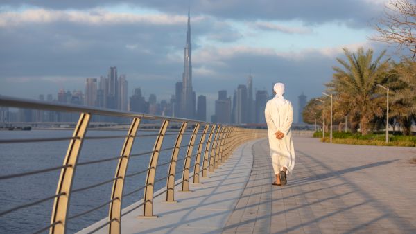 رجل إماراتي يمشي على الواجهة البحرية في دبي