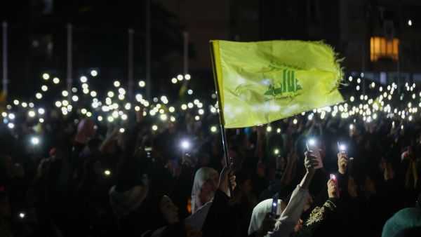 أنصار حزب الله يحملون هواتفهم ويلوحون بعلم الحزب