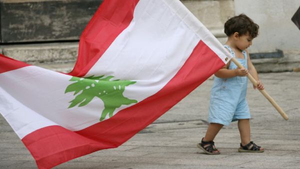 طفل صغير يحمل علم لبنان