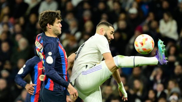 Barcelona's Spanish defender Marcos Alonso (L) fights for the ball with Real Madrid's French forward Karim Benzema during the Copa del Rey (King's Cup) semi final first leg football match between Real Madrid CF and FC Barcelona at the Santiago Bernabeu stadium in Madrid on March 2, 2023. (Photo by JAVIER SORIANO / AFP)