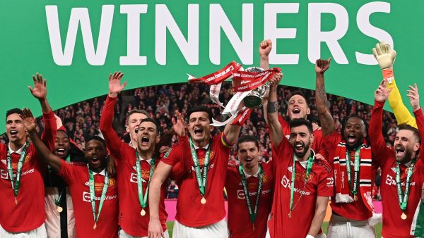 Manchester United's Portuguese midfielder Bruno Fernandes (3R) and Manchester United's English defender Harry Maguire (C) celebrate with the trophy after their victory in the English League Cup final football match between Manchester United and Newcastle United at Wembley Stadium, north-west London on February 26, 2023. Manchester United clinched their first major trophy for six years with a ruthless 2-0 win against Newcastle in the League Cup final at Wembley on Sunday. (Photo by Glyn KIRK / AFP) 