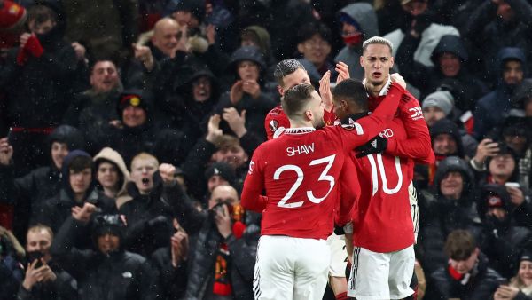 Manchester United's Brazilian midfielder Antony (R) celebrates with teammates after scoring their second goal during the UEFA Europa league round of 16 first leg football match between Manchester United and Real Betis at Old Trafford stadium in Manchester, north-west England, on March 9, 2023. (Photo by DARREN STAPLES / AFP)