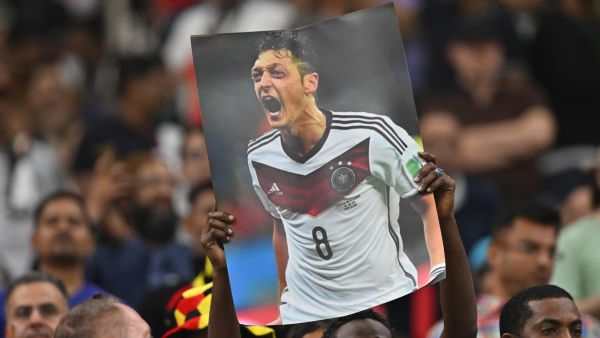 A supporter holds up a poster of German football player Mesut Ozil during the Qatar 2022 World Cup Group E football match between Costa Rica and Germany at the Al-Bayt Stadium in Al Khor, north of Doha on December 1, 2022. (Photo by Glyn KIRK / AFP)