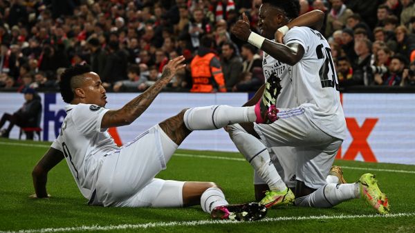 Real Madrid's Brazilian forward Vinicius Junior (R) celebrates scoring the team's second goal with Real Madrid's Brazilian forward Rodrygo (C) and Real Madrid's Brazilian defender Eder Militao during the UEFA Champions League last 16 first leg football match between Liverpool and Real Madrid at Anfield in Liverpool, north west England on February 21, 2023. (Photo by Paul ELLIS / AFP)