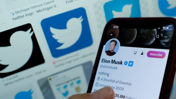 This illustration photo taken in Los Angeles on April 20, 2023, shows Elon Musk's blue tick next to his name on a smartphone. (Photo by Chris DELMAS / AFP)