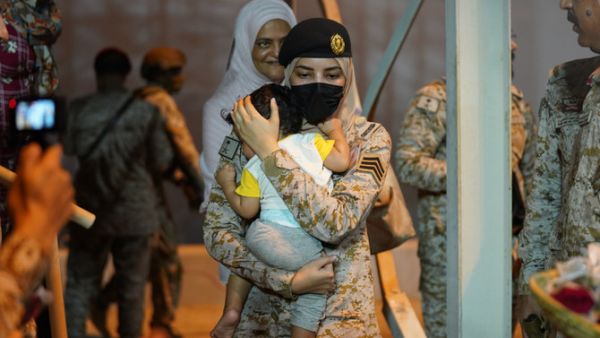 طفل ينام بين يدي مجندة سعودية في ميناء الملك فيصل