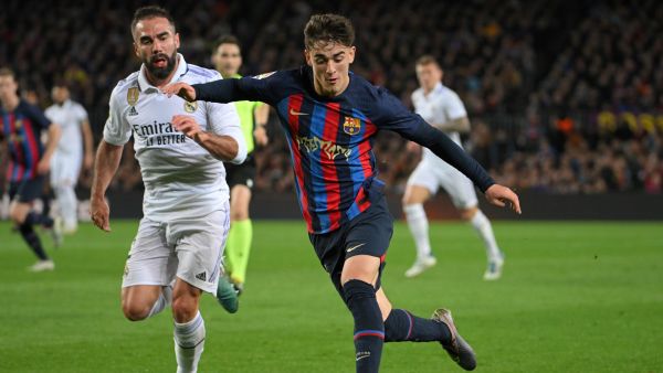 Real Madrid's Spanish defender Dani Carvajal (L) fights for the ball with Barcelona's Spanish midfielder Gavi during the Spanish league football match between FC Barcelona and Real Madrid CF at the Camp Nou stadium in Barcelona on March 19, 2023. (Photo by LLUIS GENE / AFP)