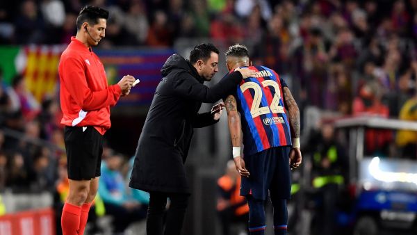 Barcelona's Spanish coach Xavi (C) talks to Barcelona's Brazilian forward Raphinha during the Copa del Rey (King's Cup) semi-final second leg football match between FC Barcelona and Real Madrid CF at the Camp Nou stadium in Barcelona on April 5, 2023. (Photo by Pau BARRENA / AFP)