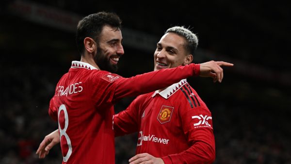 Manchester United's Portuguese midfielder Bruno Fernandes (L) celebrates with Manchester United's Brazilian midfielder Antony (R) after scoring their third goal during the English FA Cup quarter-final football match between Manchester United and Fulham at Old Trafford in Manchester, north-west England, on March 19, 2023. Man Utd won the game 3-1. (Photo by Paul ELLIS / AFP)
