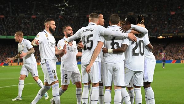 Real Madrid's players celebrate after Barcelona's Uruguayan defender Ronald Araujo scored an own goal during the Spanish league football match between FC Barcelona and Real Madrid CF at the Camp Nou stadium in Barcelona on March 19, 2023. (Photo by LLUIS GENE / AFP)