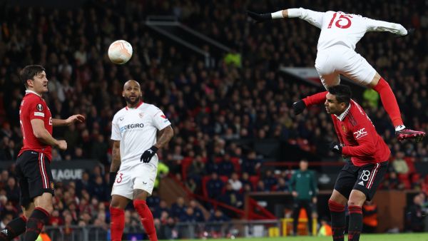 Sevilla's Moroccan forward Youssef En-Nesyri headers the ball to score a second goal, deflected in for an own goal off of Manchester United's English defender Harry Maguire (L) during the UEFA Europa league quarter-final, first leg football match between Manchester United and Sevilla at Old Trafford stadium in Manchester, north west England, on April 13, 2023. (Photo by Darren Staples / AFP)