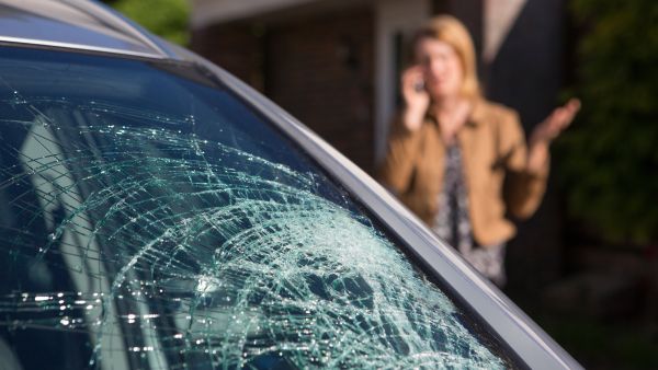Woman Phoning For Help After Car Windshield Has Broken