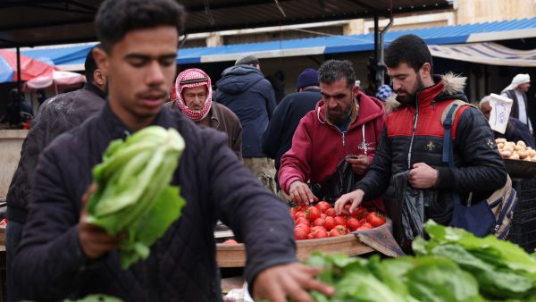 This picture taken on April 12, 2023, shows Syrians shopping at a market ahead of Iftar in Syria's rebel-held northwestern city of Idlib, during the Muslim holy month of Ramadan. (Photo by OMAR HAJ KADOUR / AFP) Syrians