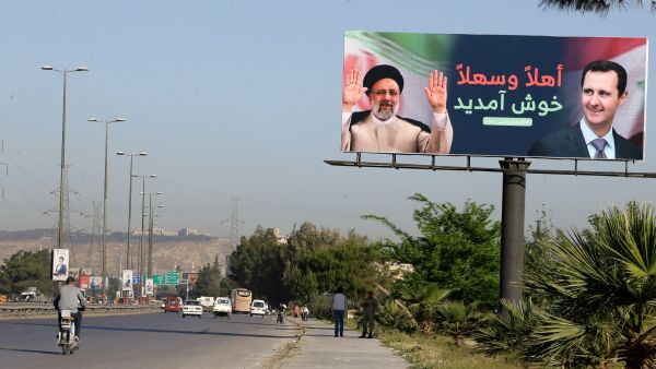 لوحة إعلانية عليها صورة رئيسي والأسدر على طريق المطار في دمشق
