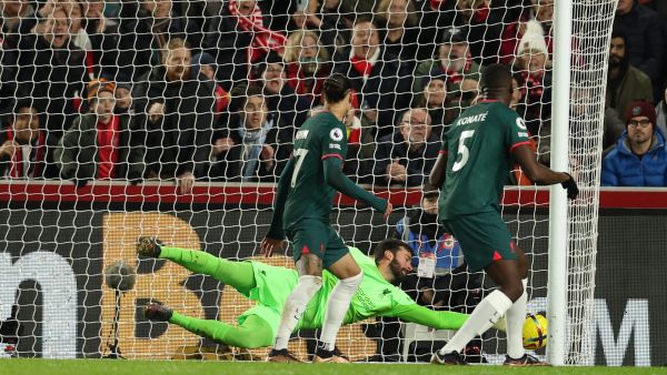 Liverpool's Brazilian goalkeeper Alisson Becker dives but is unable to prevent the ball crossing the line after a deflection off Liverpool's French defender Ibrahima Konate (R) for an own goal, during the English Premier League football match between Brentford and Liverpool at Gtech Community Stadium in London on January 2, 2023. (Photo by Adrian DENNIS / AFP)