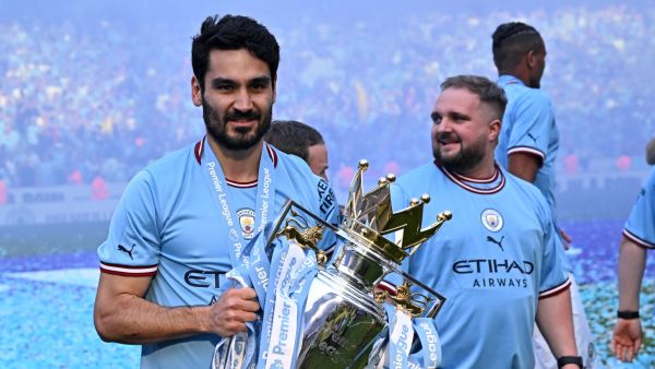 Manchester City's German midfielder Ilkay Gundogan poses with the Premier League trophy on the pitch after the presentation ceremony (Photo by Oli SCARFF / AFP)