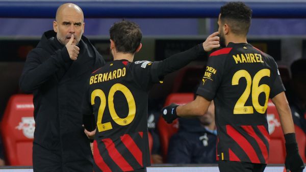 Manchester City's Spanish manager Pep Guardiola (L) gives instructions to Manchester City's Portuguese midfielder Bernardo Silva (C) and Manchester City's Algerian midfielder Riyad Mahrez (R) from the sidelines during the UEFA Champions League round of 16, first-leg football match between RB Leipzig and Manchester City in Leipzig, eastern Germany on February 22, 2023. (Photo by Odd ANDERSEN / AFP)