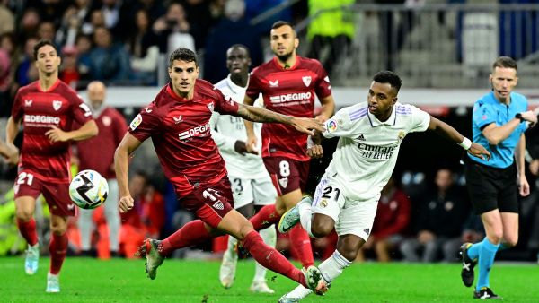 Sevilla's Argentinian forward Erik Lamela (L) fights for the ball with Real Madrid's Brazilian forward Rodrygo during the Spanish league football match between Real Madrid CF and Sevilla FC at the Santiago Bernabeu stadium in Madrid, on October 22, 2022. (Photo by JAVIER SORIANO / AFP)