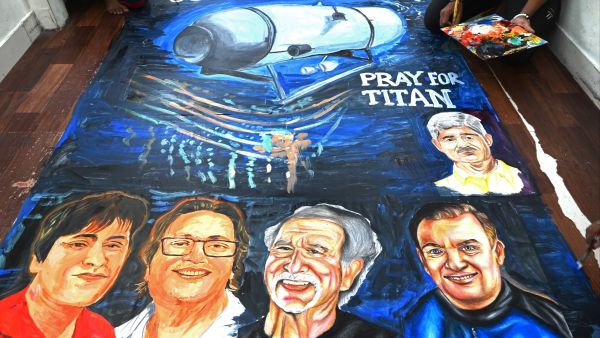 Art school students give final touches to a painting depicting five people aboard a submersible named Titan, that went missing near the wreck of the Titanic, in Mumbai on June 22, 2023. (Photo by INDRANIL MUKHERJEE / AFP) Titanic submersible