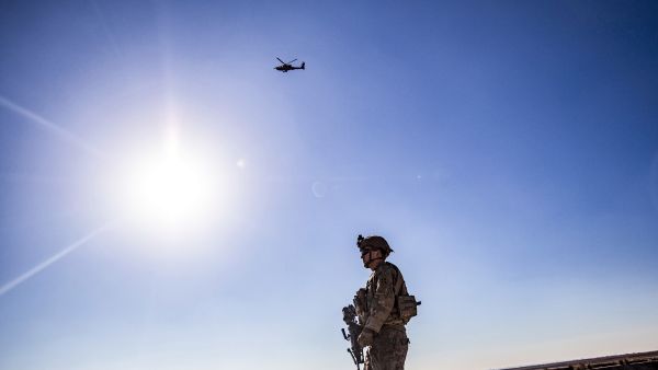A U.S. AH-64 Apache attack helicopter flies above US soldiers patrolling along the frontlines between areas held by the Syrian Democratic Forces (SDF) and Turkish-backed fighters near the village of Dardara in the countryside of Tal Tamr in Syria's northeastern Hasakeh province on December 26, 2021. (Photo by Delil souleiman / AFP) helicopter mishap