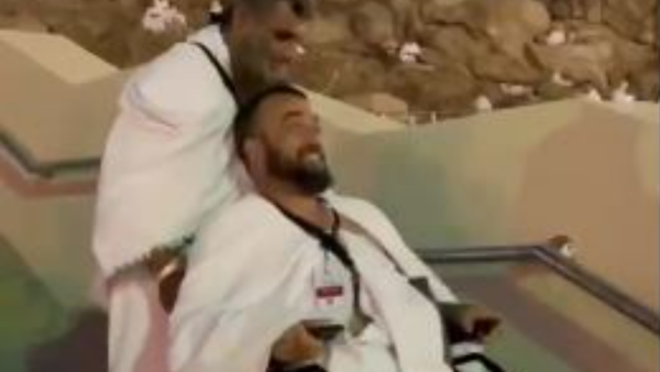معاق يساعد معاقًا آخر في الصعود إلى جبل عرفات