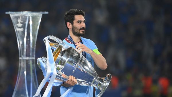 Manchester City's German midfielder #8 Ilkay Gundogan carries the European Cup trophy over to his teammates as they celebrate winning the UEFA Champions League final football match between Inter Milan and Manchester City at the Ataturk Olympic Stadium in Istanbul, on June 10, 2023. (Photo by FRANCK FIFE / AFP)