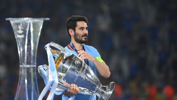 Manchester City's German midfielder #8 Ilkay Gundogan carries the European Cup trophy over to his teammates as they celebrate winning the UEFA Champions League final football match between Inter Milan and Manchester City at the Ataturk Olympic Stadium in Istanbul, on June 10, 2023. (Photo by FRANCK FIFE / AFP)