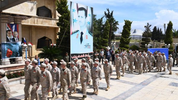 Russian soldiers parade in front of a poster of Syrian president Bashar al-Asad during a ceremony marking Soviet victory over Nazi Germany in WW II, in Aleppo's Saadallah al-Jabiri square in northern Syria on May 9, 2018. (Photo by GEORGE OURFALIAN / AFP) RELATED CONTENT Syria