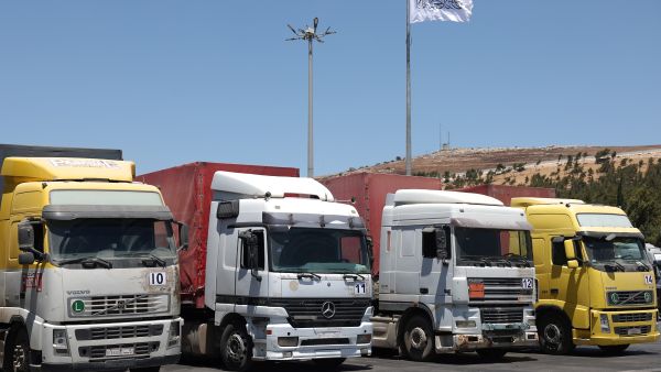 A convoy of trucks carrying humanitarian aid is seen parked after crossing the Syrian Bab al-Hawa border crossing with Turkey. (Photo by OMAR HAJ KADOUR / AFP) Aid concoys