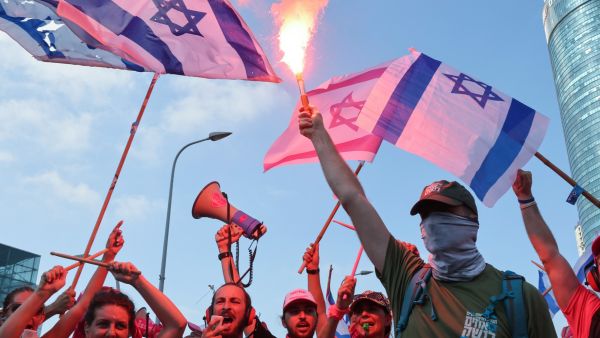 Demonstrators use flares as they stage a 'day of resistance' to protest the Israeli government's judicial overhaul bill, in Tel Aviv on July 18, 2023. (Photo by JACK GUEZ / AFP) Israeli Protestors