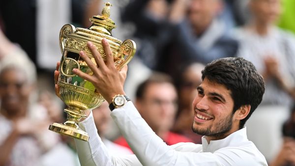 Spain's Carlos Alcaraz raises the winner's trophy after beating Serbia's Novak Djokovic during their men's singles final tennis match on the last day of the 2023 Wimbledon Championships at The All England Tennis Club in Wimbledon, southwest London, on July 16, 2023. (Photo by Glyn KIRK / AFP)