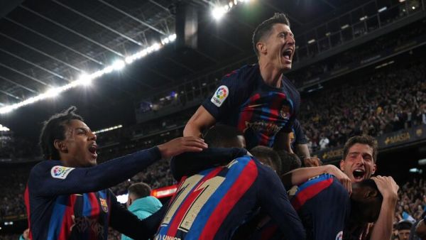 Barcelona's Ivorian midfielder Franck Kessie celebrates with teammates after scoring his team's second goal during the Spanish league football match between FC Barcelona and Real Madrid CF at the Camp Nou stadium in Barcelona on March 19, 2023. (Photo by LLUIS GENE / AFP)