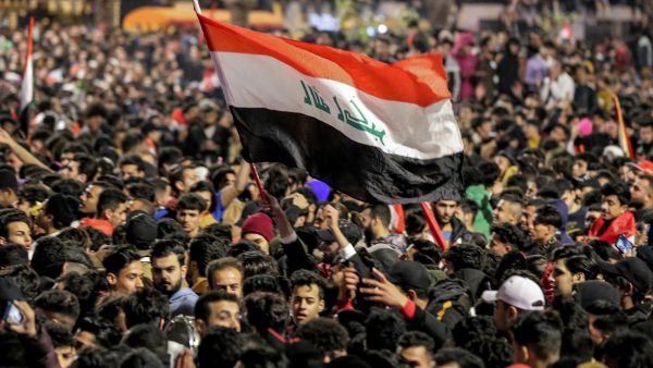 شبان عراقيون يحملون العلم العراقي