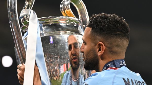 Manchester City's Algerian midfielder #26 Riyad Mahrez poses with the European Cup trophy as they celebrate winning the UEFA Champions League final football match between Inter Milan and Manchester City at the Ataturk Olympic Stadium in Istanbul, on June 10, 2023. Manchester City won the match 1-0. (Photo by Paul ELLIS / AFP)