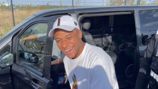 A video image grab shows Paris Saint-Germain's forward Kylian Mbappe as he stops at the entrance of the Paris Saint-Germain training grounds to meet with fans and sign autographs, after a training session in Poissy, western suburbs of Paris, on July 22, 2023. (Photo by Tom MASSON / AFP)