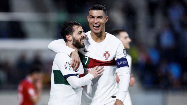 Portugal's forward Cristiano Ronaldo (R) celebrates after opening the scoring with Portugal's midfielder Bernardo Silva during the UEFA Euro 2024 group J qualification football match between Luxembourg and Portugal at the Stade de Luxembourg, in Luxembourg, on March 26, 2023. (Photo by Kenzo TRIBOUILLARD / AFP)