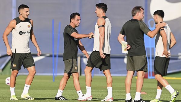Barcelona's Spanish coach Xavi (2L) shakes hands with Barcelona's Polish forward #9 Robert Lewandowski (C) next to Barcelona's Spanish forward #07 Ferran Torres (L) during a training session at the Joan Gamper training ground in Sant Joan Despi, near Barcelona, on August 12, 2023, on the eve of their first Spanish Liga football match of this season, against Getafe CF. (Photo by Pau BARRENA / AFP)