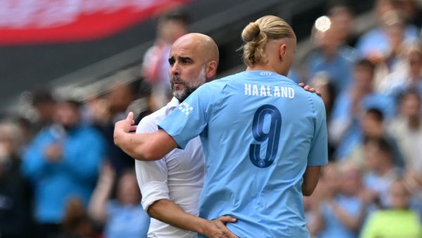 Manchester City's Spanish manager Pep Guardiola (L) gestures to Manchester City's Norwegian striker Erling Haaland (R) as he leaves the game, substituted during the English FA Community Shield football match between Arsenal and Manchester City at Wembley Stadium, in London, August 6, 2023. (Photo by Glyn KIRK / AFP)