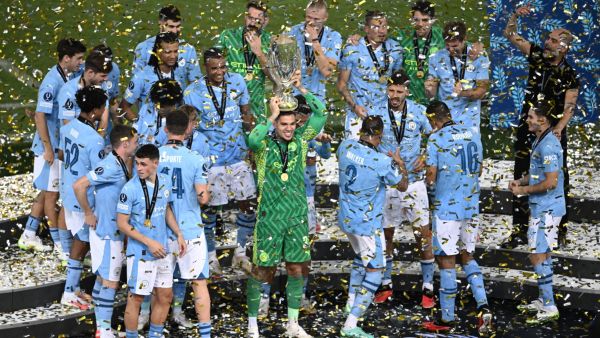 Manchester City's players celebrate on the podium after winning the 2023 UEFA Super Cup football match between Manchester City and Sevilla at the Georgios Karaiskakis Stadium in Piraeus on August 16, 2023. (Photo by Angelos Tzortzinis / AFP)