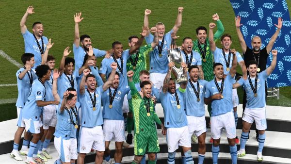 Manchester City's players celebrate on the podium after winning the 2023 UEFA Super Cup football match between Manchester City and Sevilla at the Georgios Karaiskakis Stadium in Piraeus on August 16, 2023. (Photo by Angelos Tzortzinis / AFP)