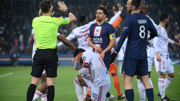 Lyon's French midfielder Corentin Tolisso grimaces next to the referre and Paris Saint-Germain's Brazilian defender Marquinhos during the French L1 football match between Paris Saint-Germain (PSG) and Olympique Lyonnais (OL) at The Parc des Princes Stadium in Paris on April 2, 2023. (Photo by FRANCK FIFE / AFP)