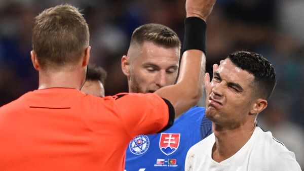Portugal's forward #07 Cristiano Ronaldo (R) is shown a yellow card by Swedish referee Glenn Nyberg reacts during during the UEFA EURO 2024 qualifying football match between Slovakia and Portugal in Bratislava on September 8, 2023. (Photo by VLADIMIR SIMICEK / AFP)