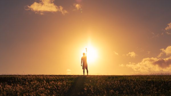Strong determined man putting fist up to the sky. Mental and physical strength concept.
