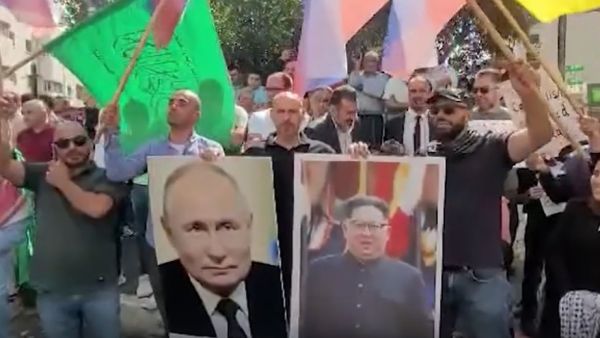 متظاهرون في الخليل يرفعون صور بوتين وكيم جونغ اون