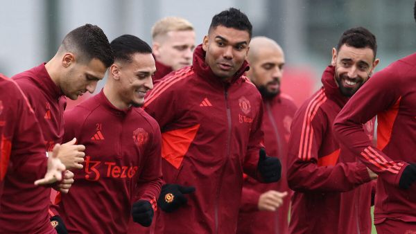 Manchester United's Brazilian striker Antony (2nd L) runs with Portuguese midfielder Bruno Fernandez (R) and Brazilian midfielder Casemiro (C) during a training session at the Carrington Training Complex in Manchester, north-west England on October 2, 2023 ahead of their UEFA Champions League Group A football match against Galatasaray. (Photo by Darren Staples / AFP)
