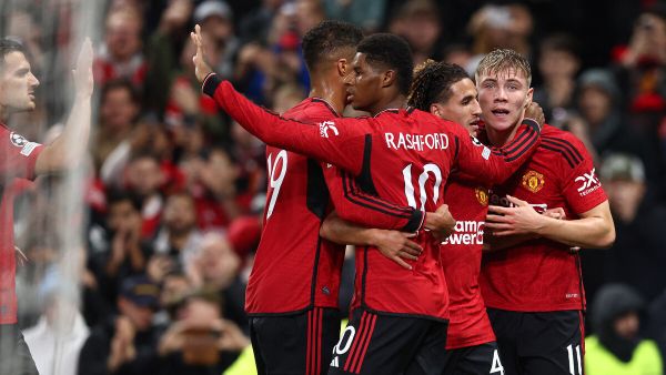 Manchester United's Danish striker #11 Rasmus Hojlund (R) celebrates scoring the opening goal during the UEFA Champions league group A football match between Manchester United and Galatasaray at Old Trafford stadium in Manchester, north west England, on October 3, 2023. (Photo by Darren Staples / AFP)