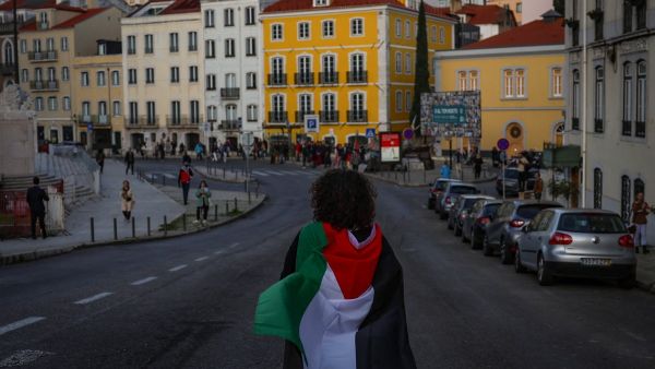 A woman wearing a Palestinian flag takes part in a demonstration to demand a cease-fire in the Palestinian territories, in Lisbon on November 18, 2023. (Photo by PATRICIA DE MELO MOREIRA / AFP) Palestinian flag