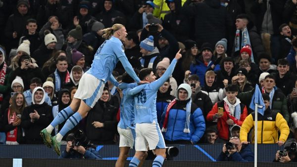 Manchester City's Argentinian striker #19 Julian Alvarez (R) celebrates scoring the team's third goal during the UEFA Champions League Group G football match between Manchester City and RG Leipzig at the Etihad Stadium, in Manchester, north west England, on November 28, 2023. (Photo by Paul ELLIS / AFP)