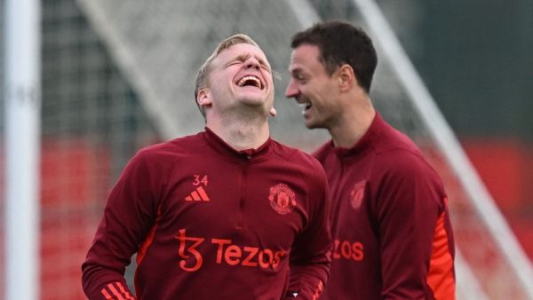 Manchester United's Dutch midfielder #34 Donny van de Beek (L) and Manchester United Northern Irish defender #35 Jonny Evans react as they attend attends a training session at the Carrington Training Complex in Manchester, north-west England on October 23, 2023 ahead of their UEFA Champions League Group A football match against FC Copenhagen. (Photo by Paul ELLIS / AFP)