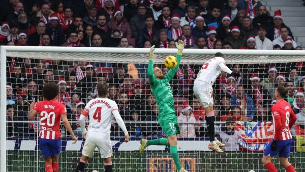 Sevilla's Moroccan forward #15 Youssef En-Nesyri challenges Atletico Madrid's Slovenian goalkeeper #13 Jan Oblak during the Spanish league football match between Club Atletico de Madrid and Sevilla FC at the Metropolitano stadium in Madrid on December 23, 2023. (Photo by Pierre-Philippe MARCOU / AFP)